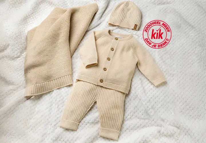Een zacht beige babysetje met een vest, broek en bijpassend mutsje, uitgestald op een gestructureerde deken.