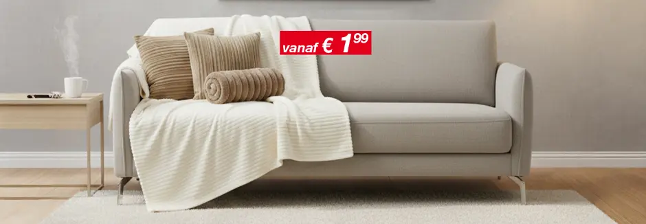 Lichte woonkamer met grijze bank, kussens en plaid, bijzettafel en vloerlamp