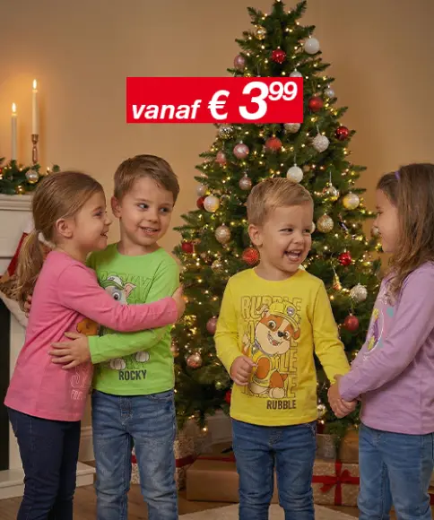 Drie kinderen in kleurrijke T-shirts staan naast een versierde kerstboom, met kaarsen op de achtergrond en een prijskaartje boven hun hoofd.