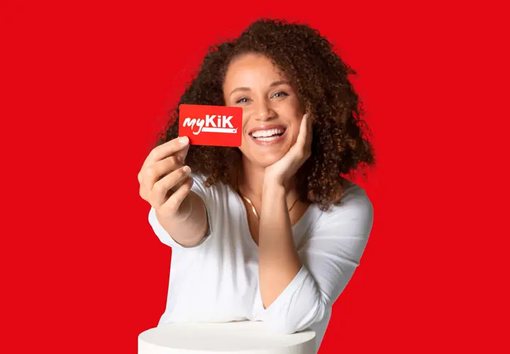 Persoon met krullend haar houdt een rode myKik kaart vast voor een rode achtergrond.