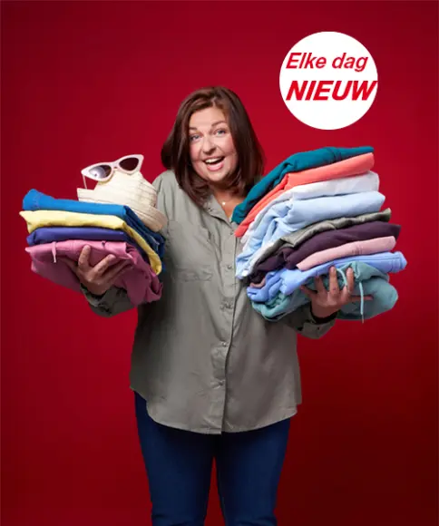 Een vrouw houdt verschillende stapels opgevouwen kleding vast tegen een rode achtergrond - de nieuwste modetrends voor dames en heren