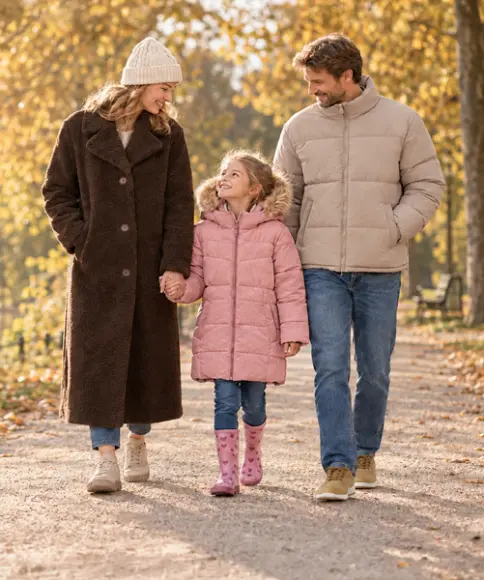 Gezin in warme jassen tijdens een herfstwandeling langs het meer