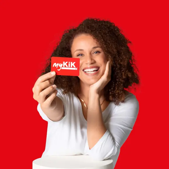 Persoon met krullend haar houdt een rode myKik kaart vast voor een rode achtergrond.