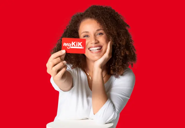 Een vrouw houdt glimlachend de myKiK-voordeelkaart voor de camera.
