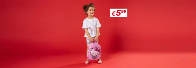 Een kind staat voor een rode achtergrond, gekleed in een gestreept Hello Kitty-shirt en korte broek, met een roze Hello Kitty-rugzak in de hand